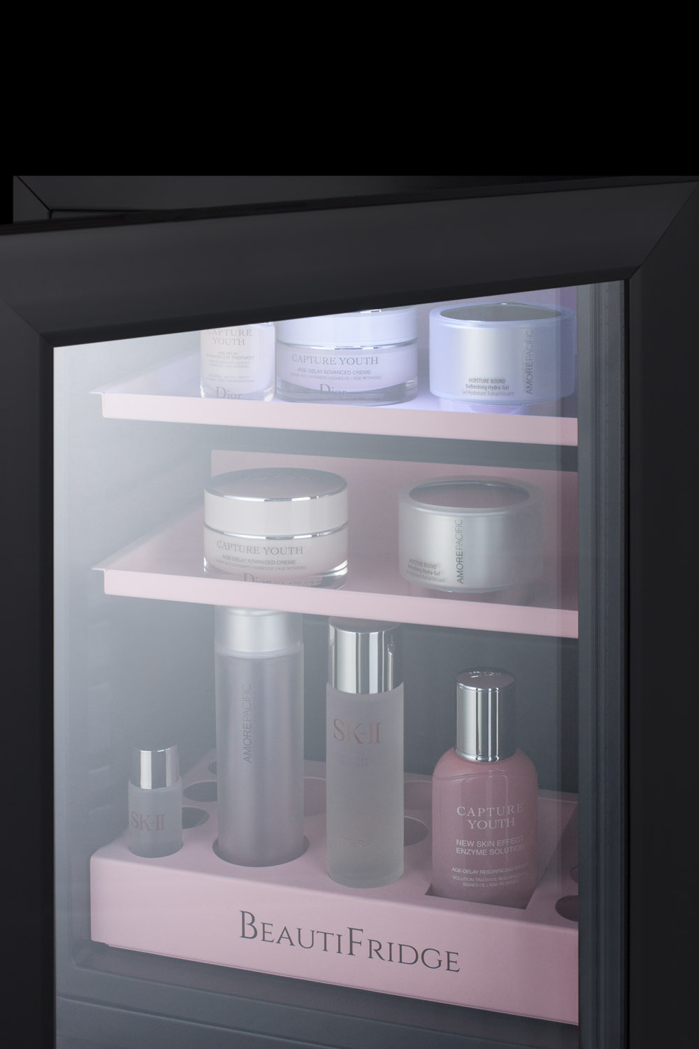 BeautiFridge compact cosmetics cooler with glass door, black cabinet, lock, matte blush pink shelves, and digital controls set for the storage of beauty products
